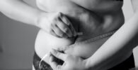 grayscale photo of woman holding her breast