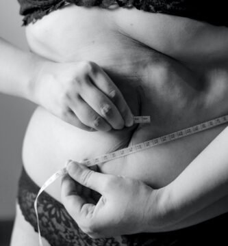 grayscale photo of woman holding her breast