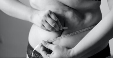 grayscale photo of woman holding her breast