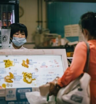woman in red tank top wearing white mask